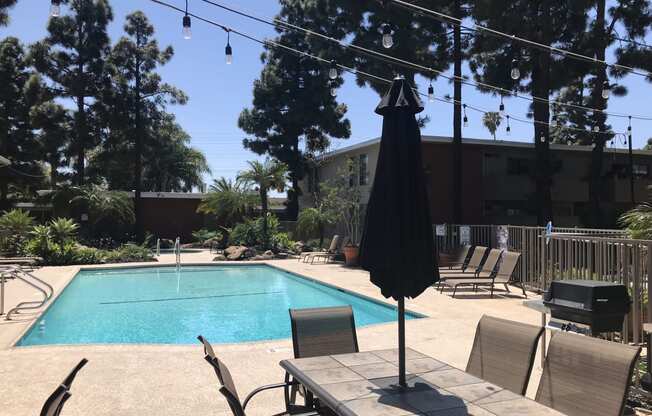 a swimming pool with a table and chairs around it