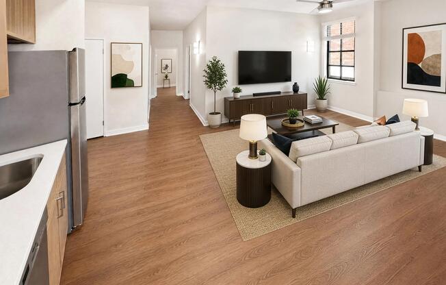 Open living room and kitchen with laminate flooring and refreshed lighting.