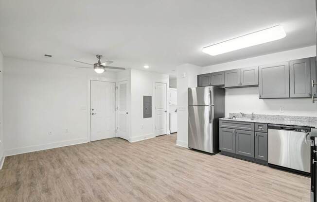 A kitchen with a refrigerator, dishwasher, and oven.