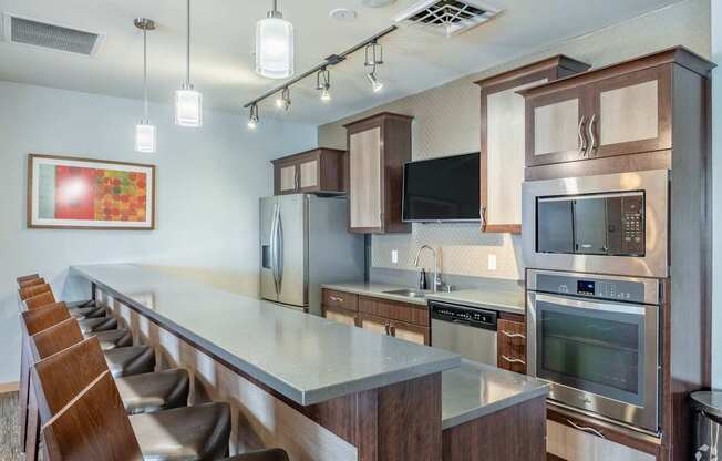 A modern kitchen with a long counter and stainless steel appliances.