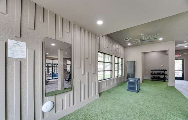 a large room with a green carpet and a large mirror on the wall