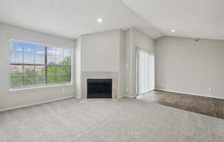B2 living room with a fireplace and a large window at Jefferson Place Apartments in Irving, TX