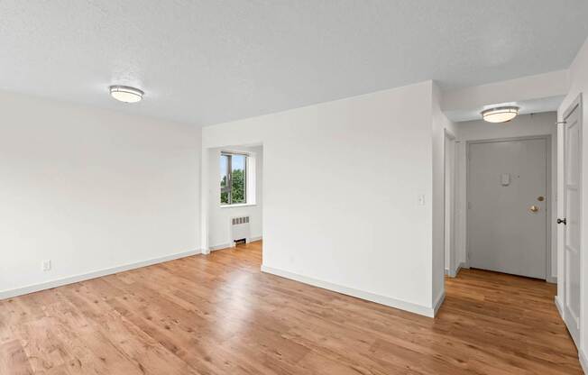 an empty living room with white walls and wood floors