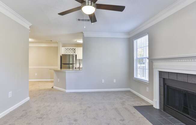 a living room with a fireplace and a ceiling fan