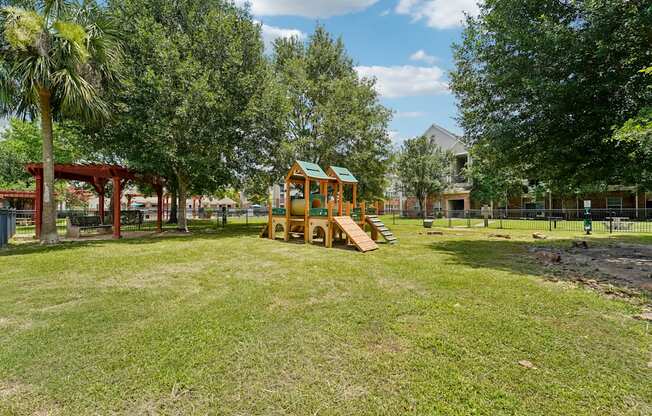 A playground with a wooden swing set and a green roof.