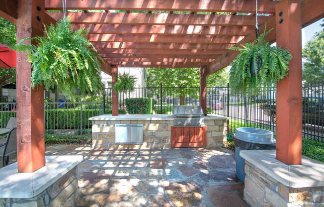 a patio with a barbecue grill and a pergola