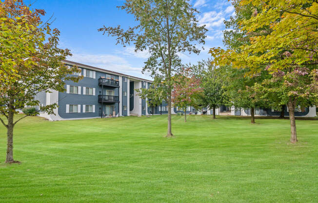 the view of a building with grass and trees in front of it