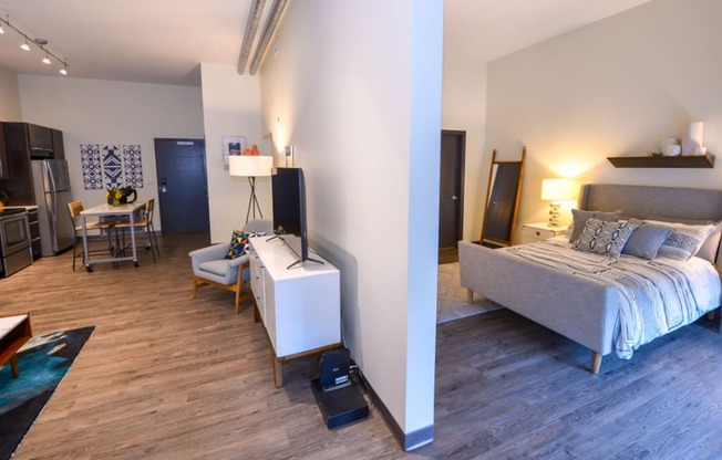a bedroom with a bed and a desk in a room