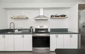 a kitchen with white cabinets and a black counter top