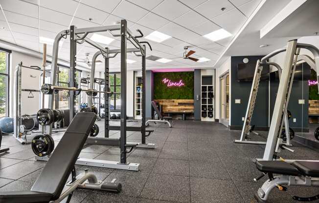 a gym with exercise equipment and a wall with a mural