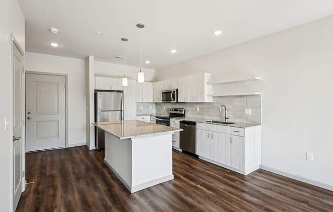 A modern kitchen with white cabinets and a wooden island.