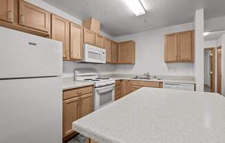 A kitchen with white appliances and wooden cabinets.