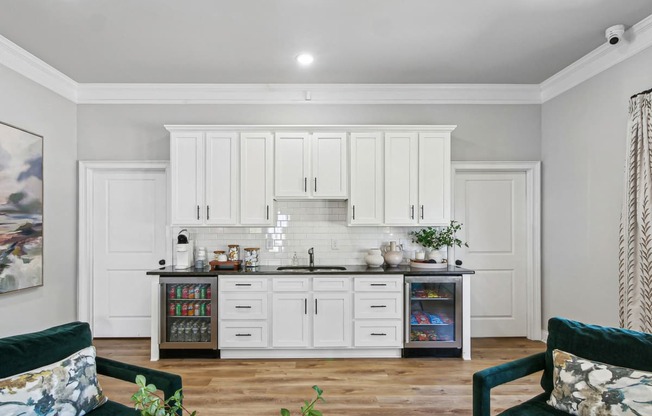 a kitchen with white cabinets and a counter top with a sink