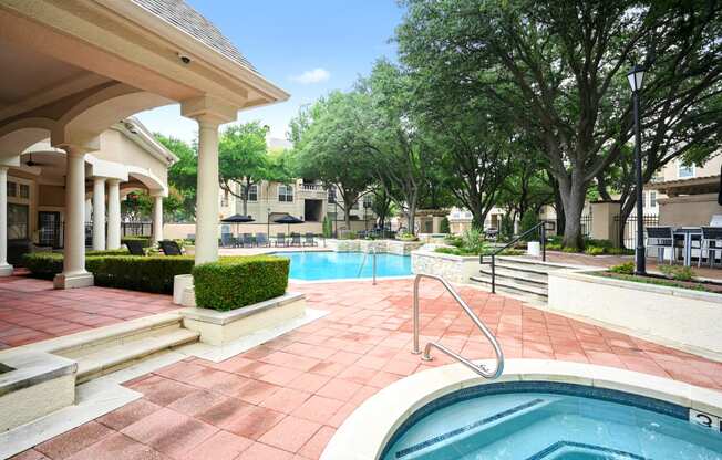 a swimming pool with a spa in front of a resort style pool