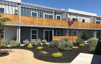 a view of the front of a building with a garden in front of it