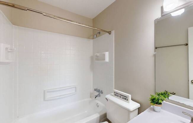 a bathroom with a tub and a sink and a toilet