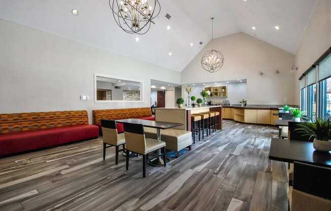 a dining room with tables and chairs and a kitchen in the background