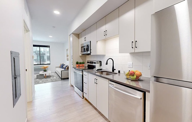 A modern kitchen with stainless steel appliances and white cabinets.