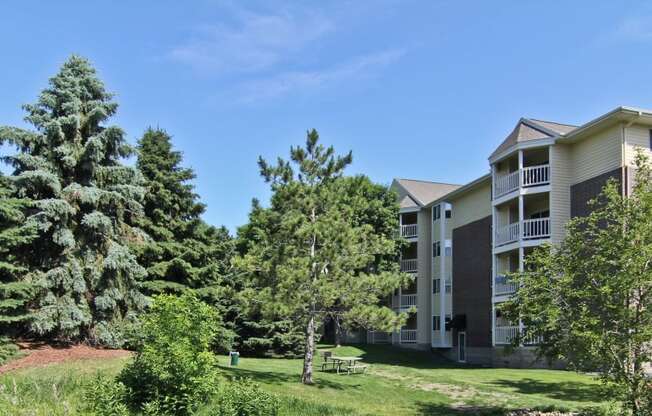 an apartment building on a hill with trees