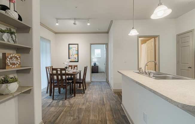 a kitchen and dining room with a table and chairs and a sink