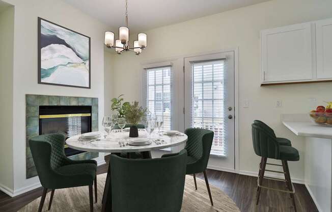 A dining room with a white table and green chairs.