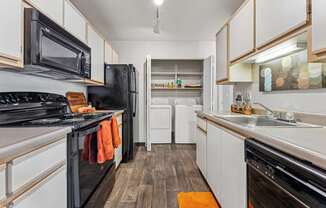 A kitchen with black appliances and white cabinets.