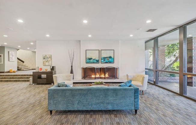 A modern living room with a fireplace and a blue couch.