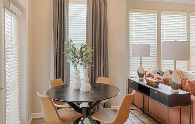 A dining room with a round table and chairs.
