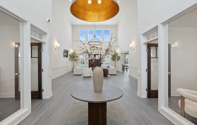 a living room with white walls and white furniture and a large pendant light