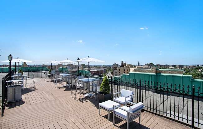 a rooftop terrace with tables and chairs and a view of the city