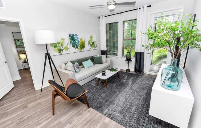 a living area with a couch coffee table and a large window