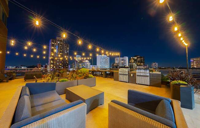 a roof top bar with a view of the city at night