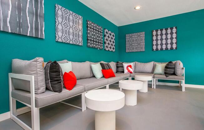 a waiting room with couches and chairs and paintings on the wall