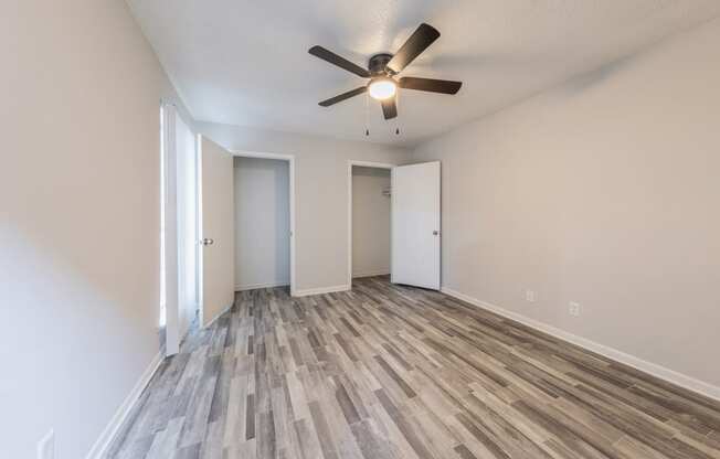 an empty living room with a ceiling fan