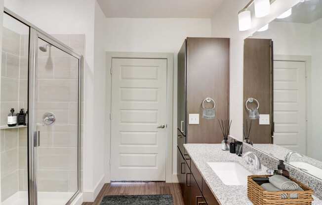 a bathroom with a shower and a sink and a mirror