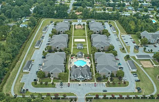 A bird's eye view of a residential area with houses and a swimming pool.