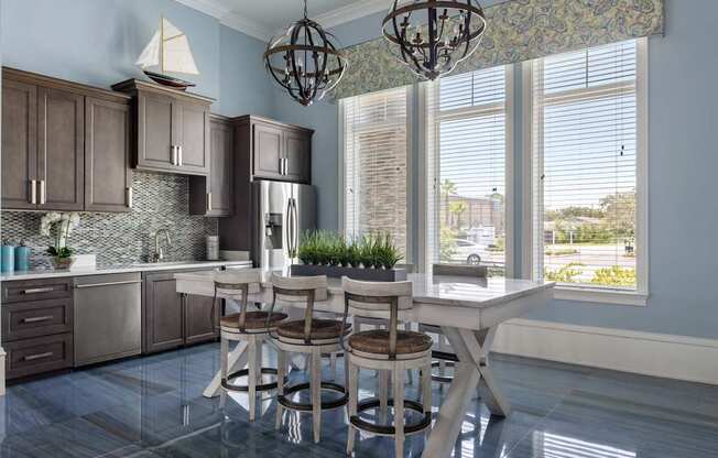 A kitchen with a table and chairs in front of a window.