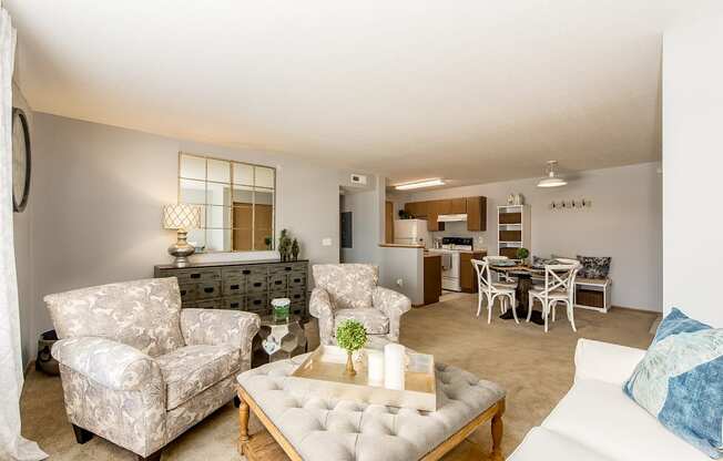 A living room with a white couch, a coffee table, and a dining table.