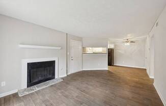 A living room with a fireplace and wood flooring at Gwinnett Square Apartments in Duluth, GA