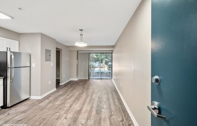 Large living space with sliding glass door in our newly renovated homes at Trillium Apartments, Fairfax, 22031