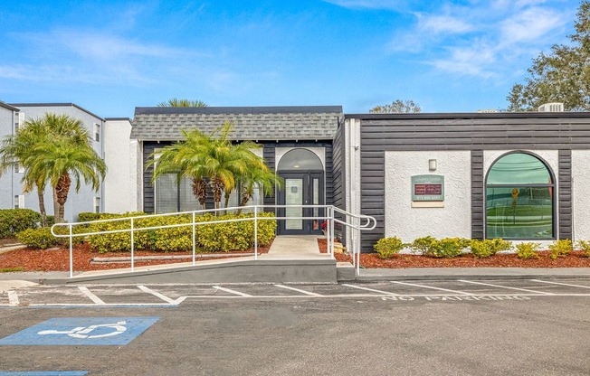 a building with palm trees and a parking lot