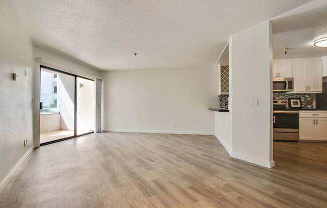 an empty living room with a kitchen in the background  at Masselin Park West, Los Angeles, 90036