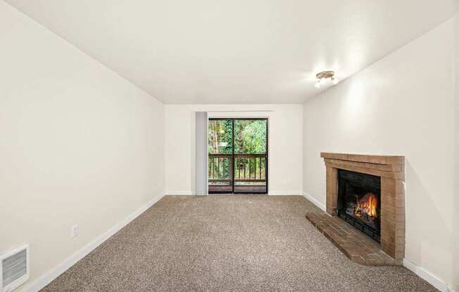 A room with a fireplace and a window with a view of trees.