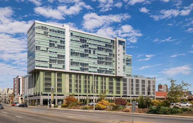 A modern glass building with a street in front of it.