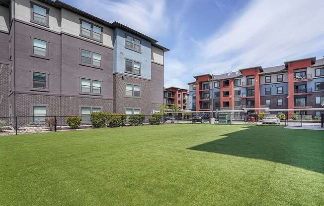 A large grassy area in front of apartment buildings.
