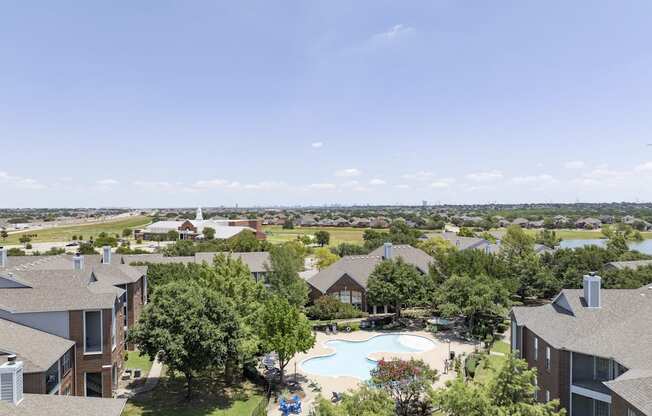 A large apartment complex with a pool and a view of the water.