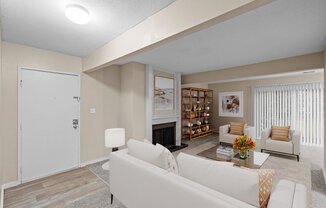 a living room with white furniture and a fireplace