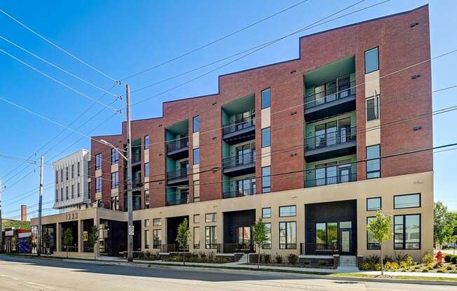 a large brick building with many windows and a street in front of it
