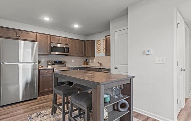 a kitchen with a island and a stainless steel refrigerator