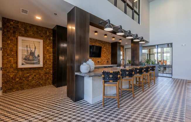 A room with a checkered floor and a long table with chairs.